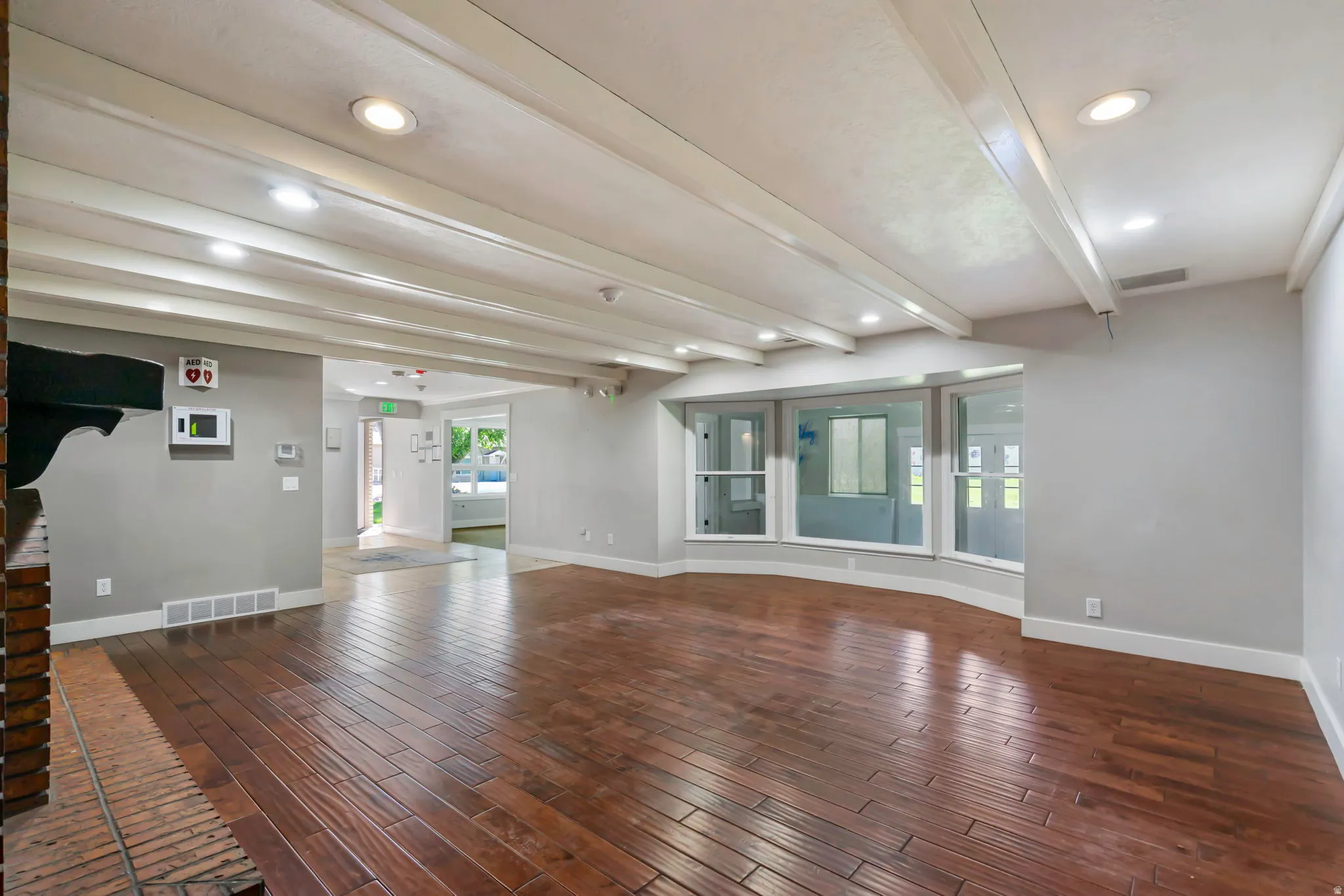 Spare room with beam ceiling, recessed lighting, and dark wood-style flooring