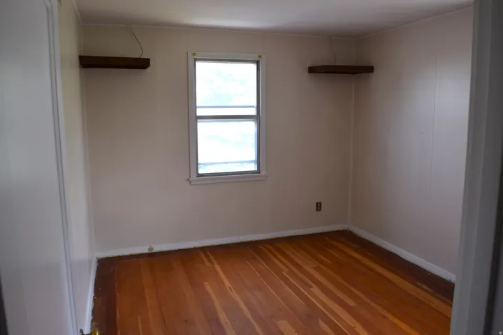 Empty room with wood-type flooring and baseboards