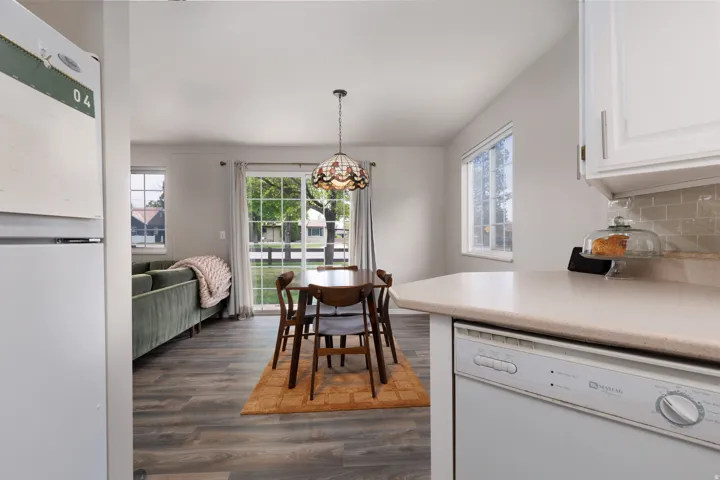 Dining space featuring dark wood-style floors, plenty of natural light, and a chandelier