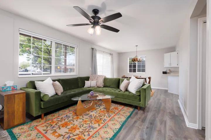 Living room with ceiling fan and dark wood-style floors
