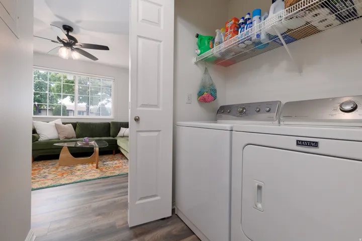 Laundry area featuring dark wood-style floors, ceiling fan, and washer and clothes dryer