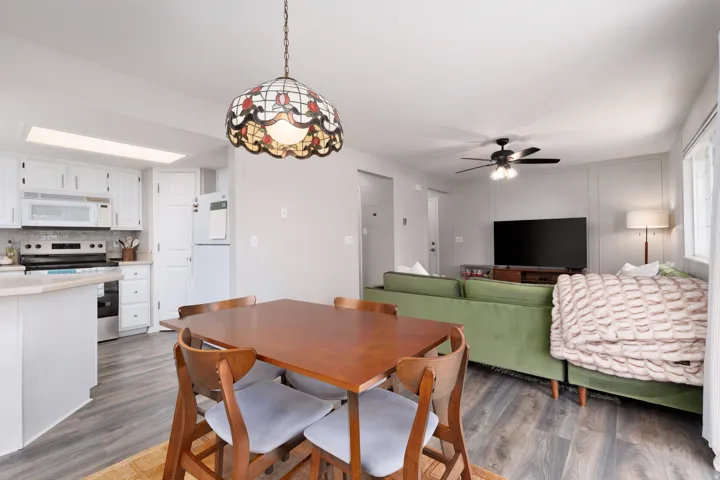 Dining area featuring dark wood-style flooring and ceiling fan