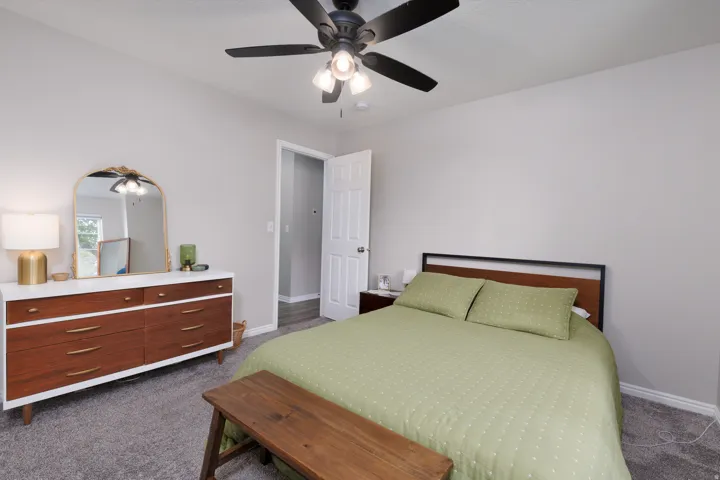 Bedroom featuring dark carpet and a ceiling fan