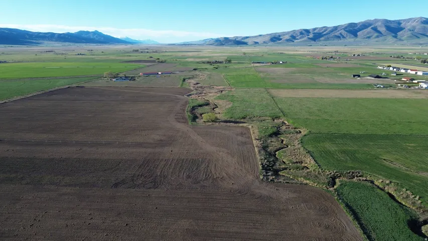 Overview of rural landscape featuring extensive farmland and a mountainous background