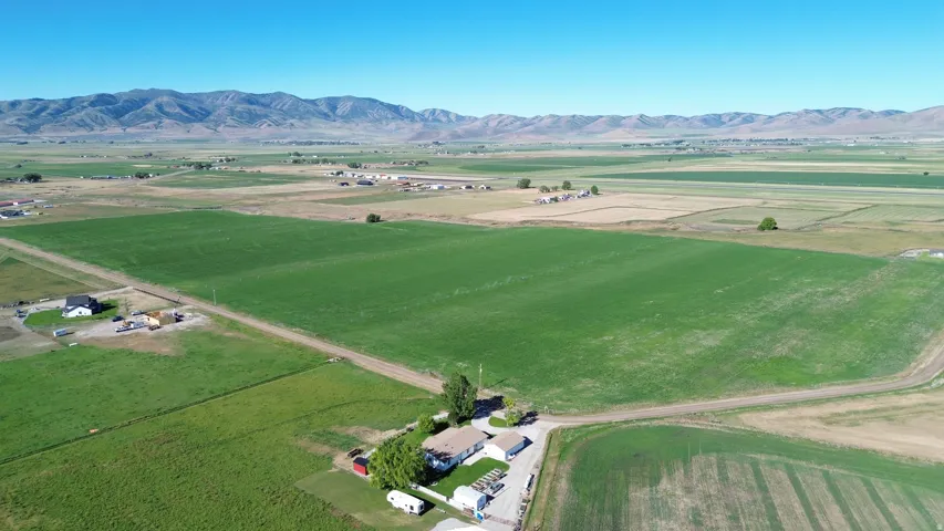 Expansive agricultural land featuring a large green field and distant mountain range