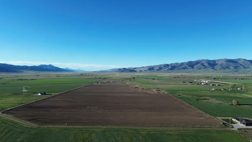 View of mountain backdrop with rural landscape and rows of crops