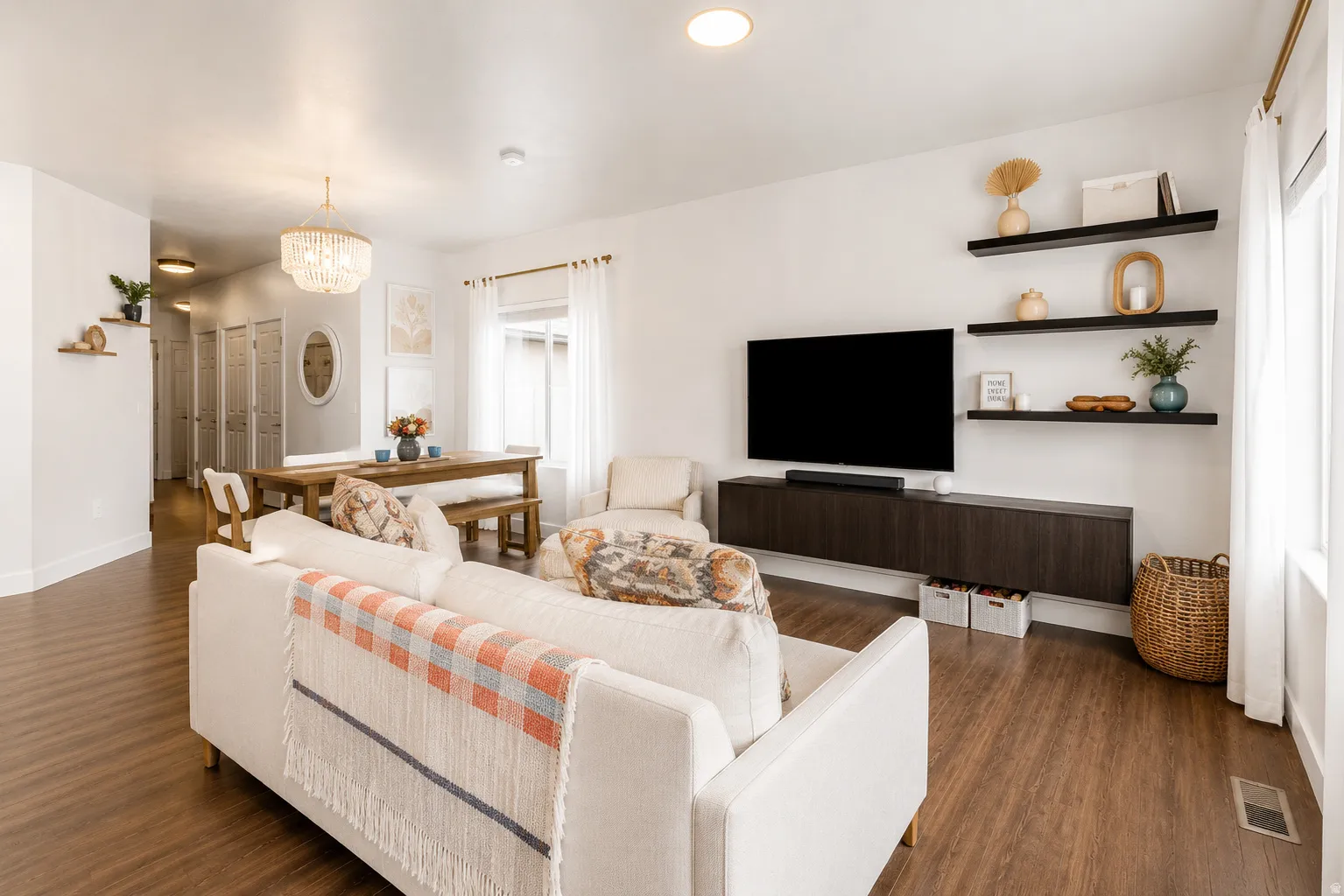 Open-concept living space featuring wood-finish flooring, recessed lighting, and a modern chandelier