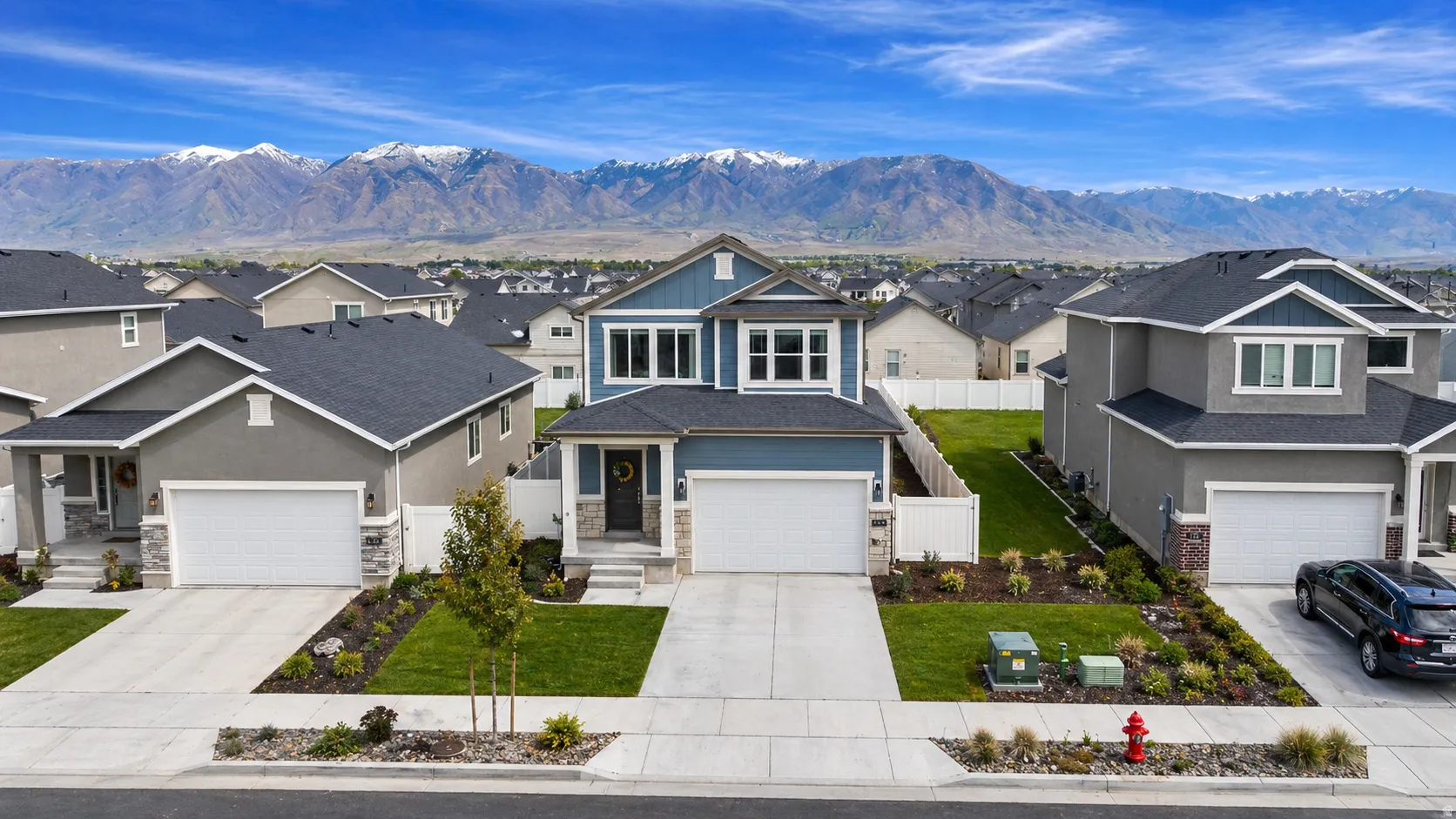 Craftsman-style home featuring a residential view, stone siding, driveway, and a mountain view