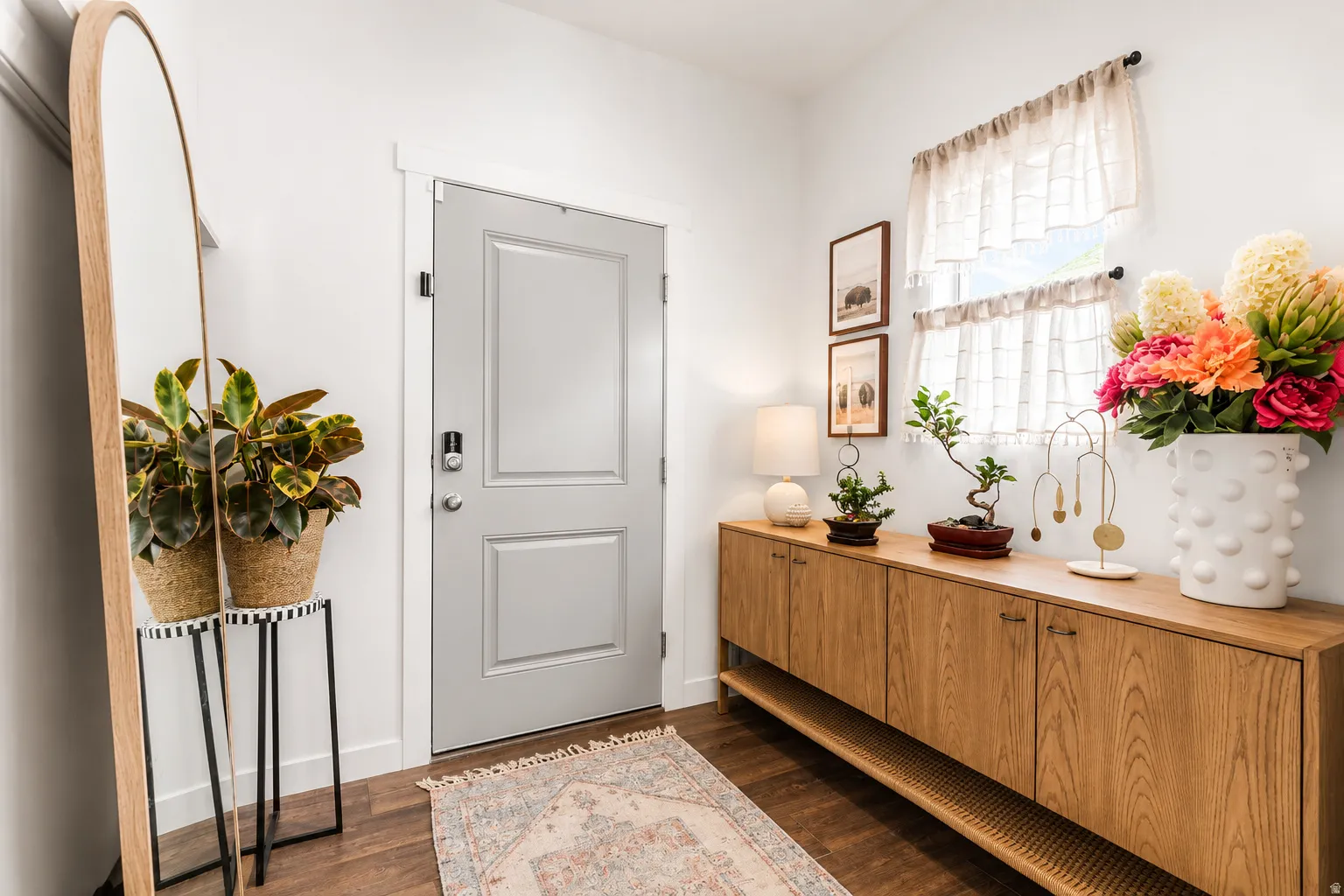 Entryway featuring wood-finish flooring and a light gray panel door with smart lock hardware