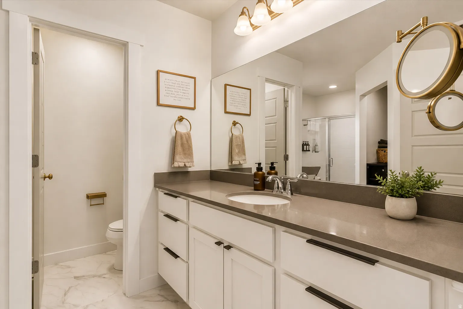 Contemporary bathroom featuring a spacious vanity with a light gray countertop, undermount sink, and chrome faucet