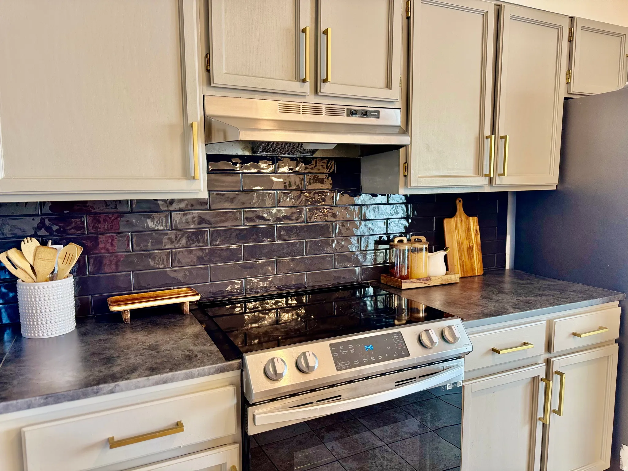 Kitchen with stainless steel appliances, dark countertops, and backsplash