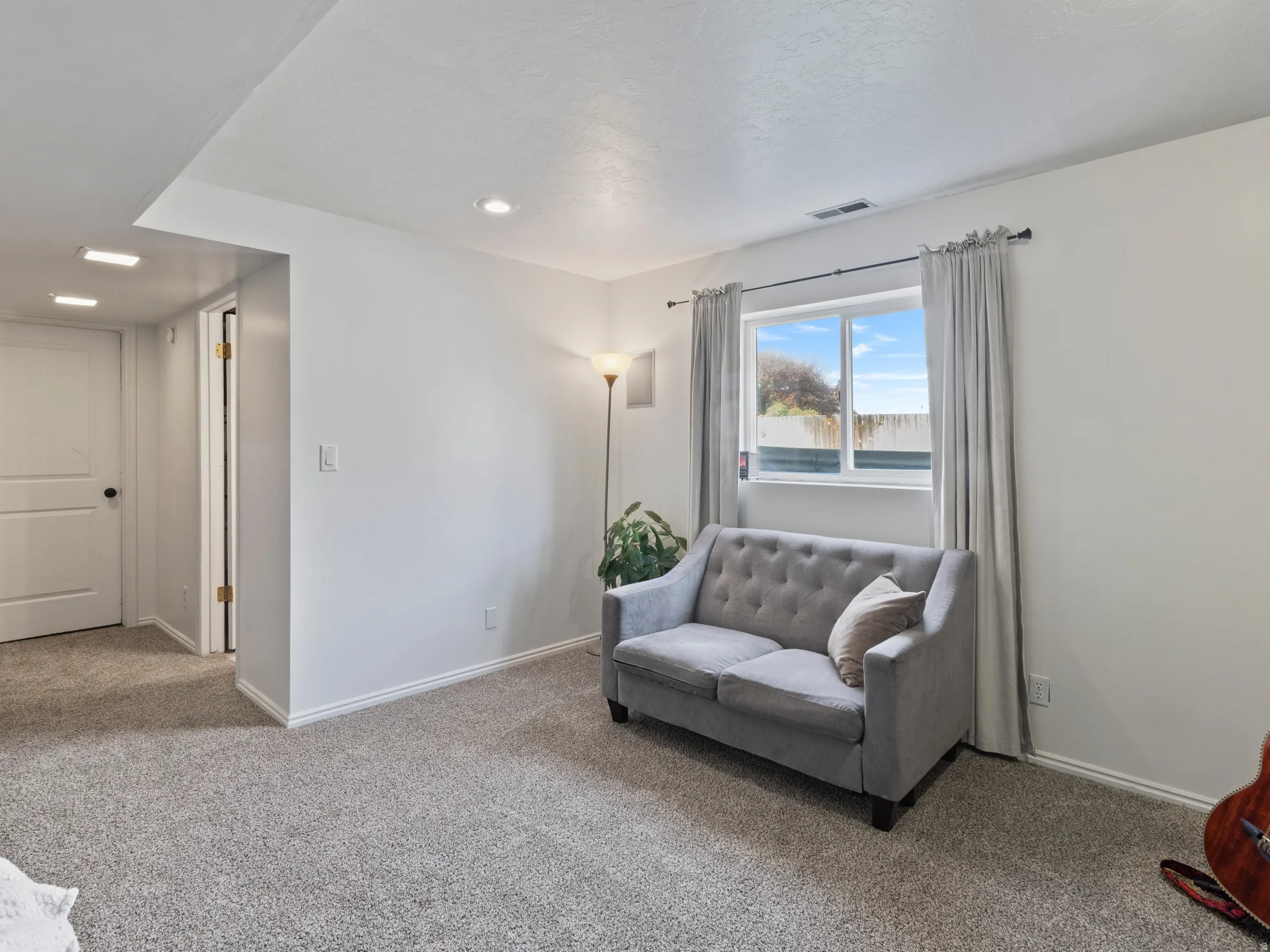 Sitting room featuring baseboards and carpet flooring