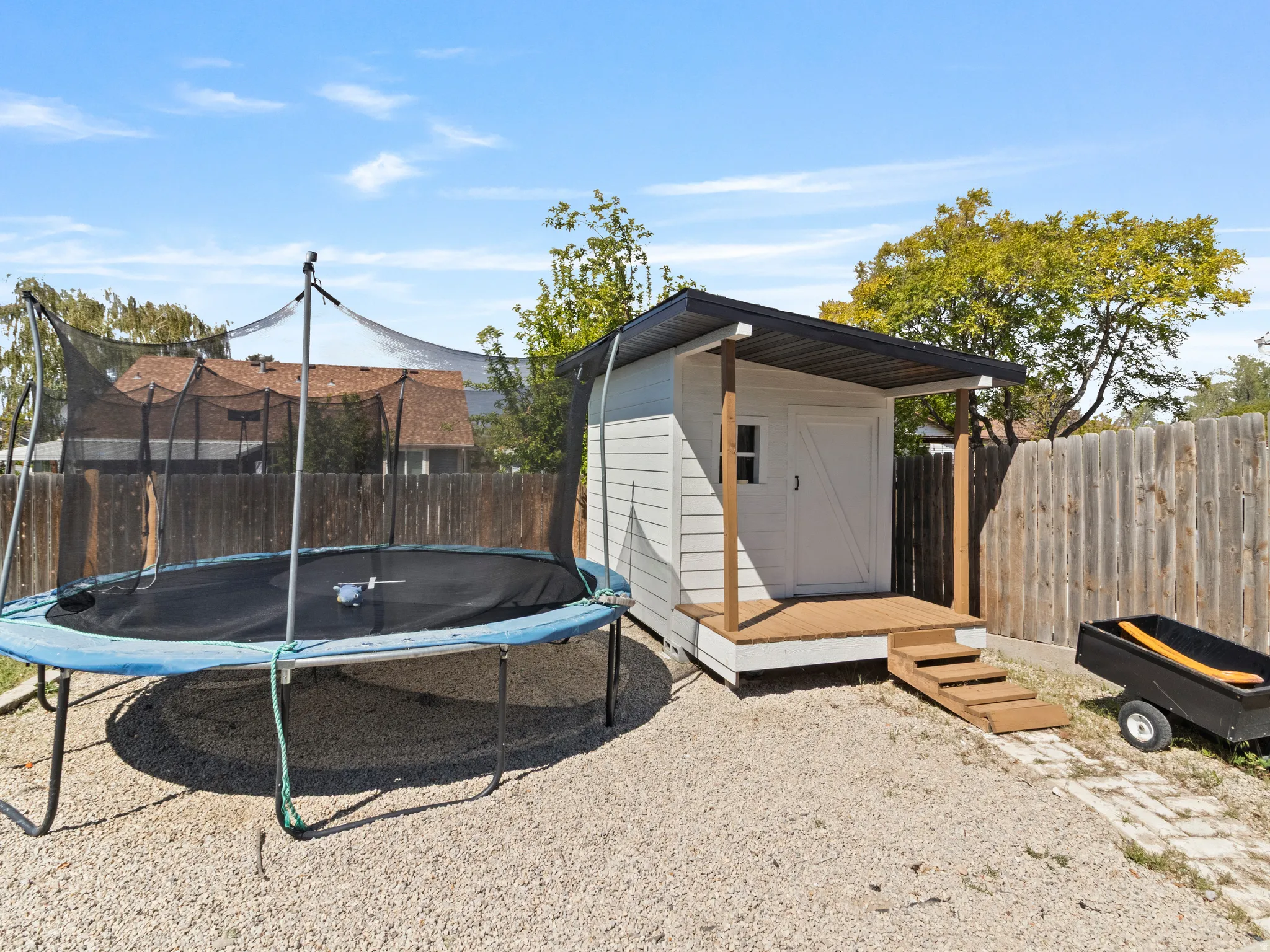 View of shed with a trampoline and a fenced backyard