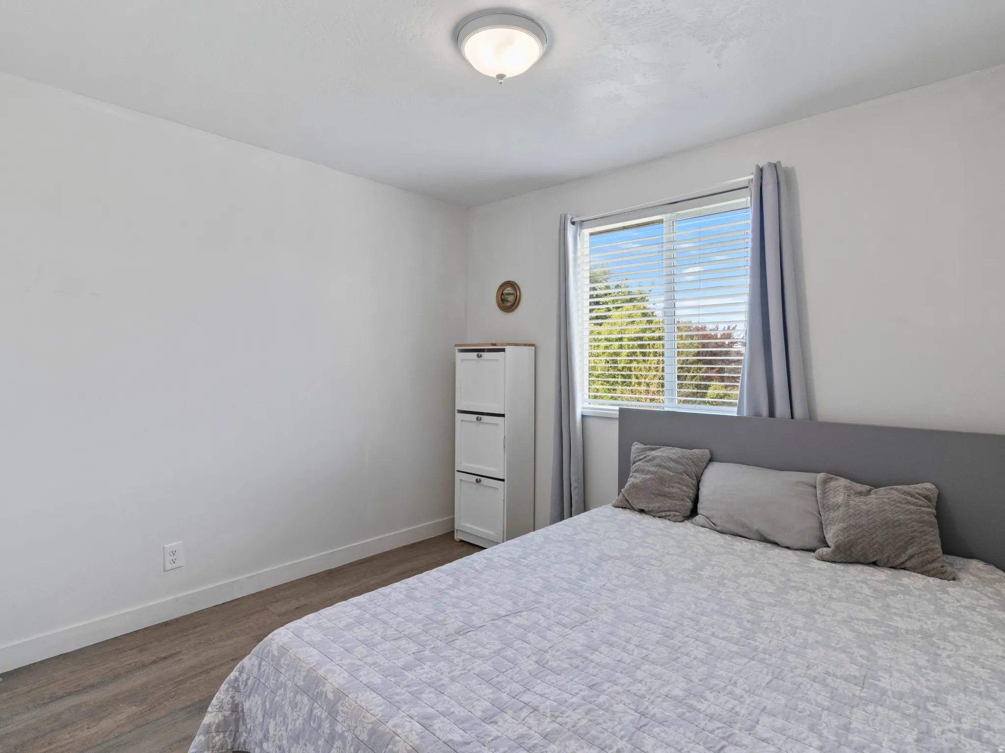 Bedroom with baseboards and dark wood-type flooring