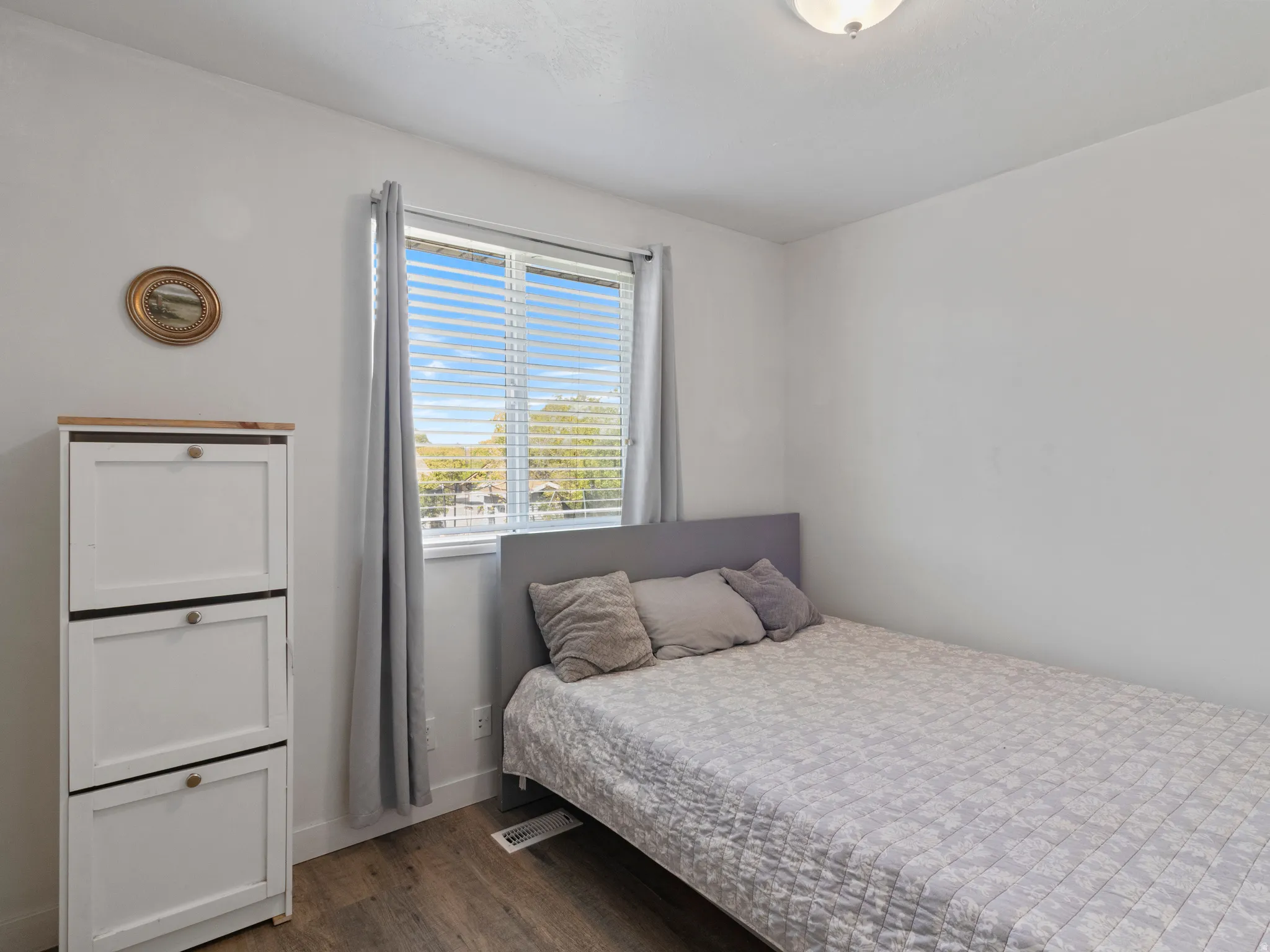 Bedroom with dark wood-style floors and baseboards