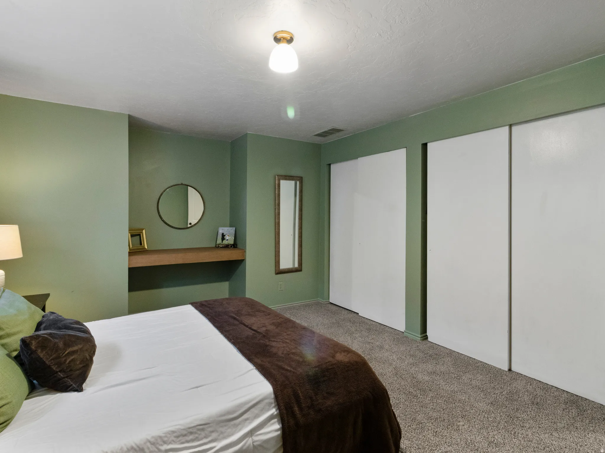 Carpeted bedroom with multiple closets