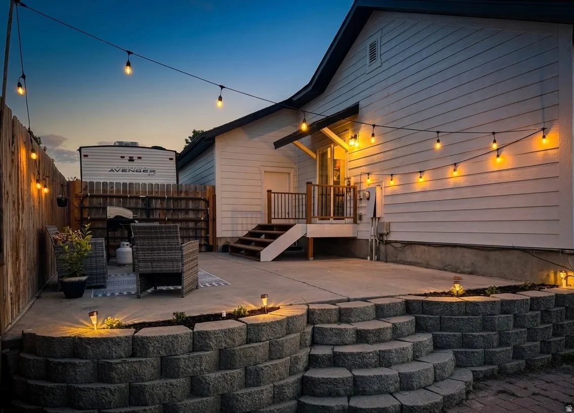Rear view of house with a fenced backyard, a wooden deck, and a patio