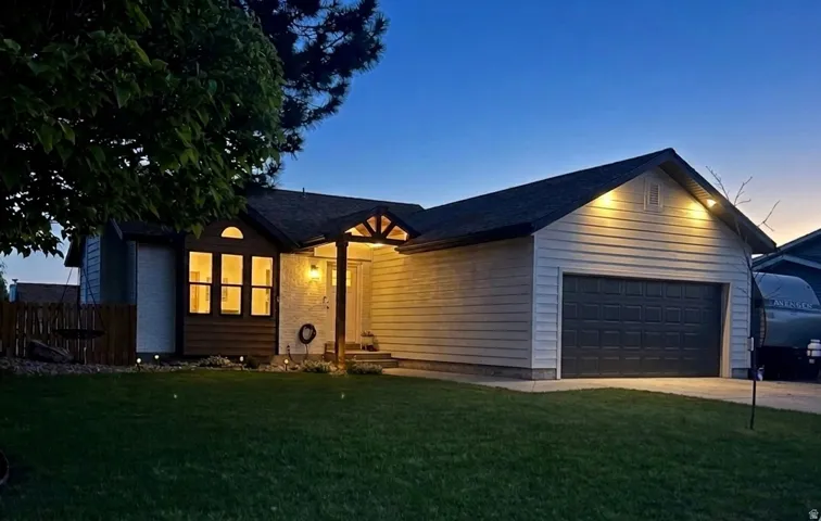 Ranch-style house featuring a garage and concrete driveway