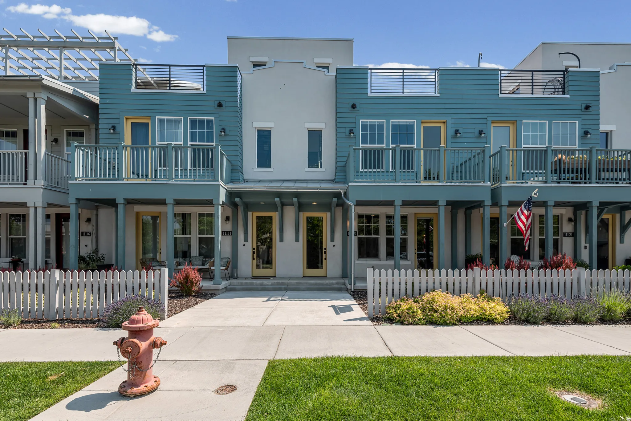 Contemporary multi-story facade featuring distinct blue siding and light grey stucco accents