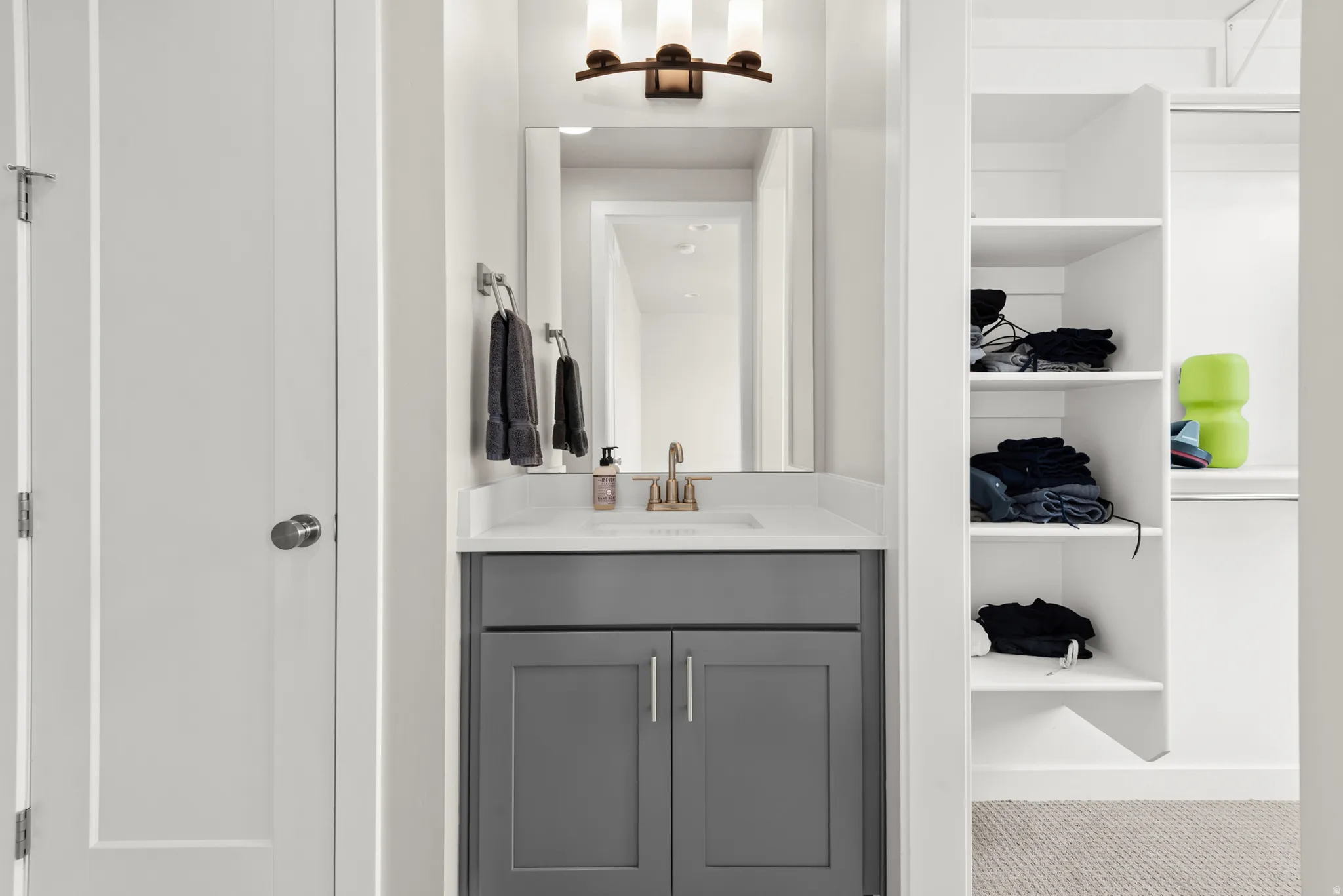 Vanity area featuring a rectangular undermount sink, quartz-finish countertop, and bronze-finish faucet