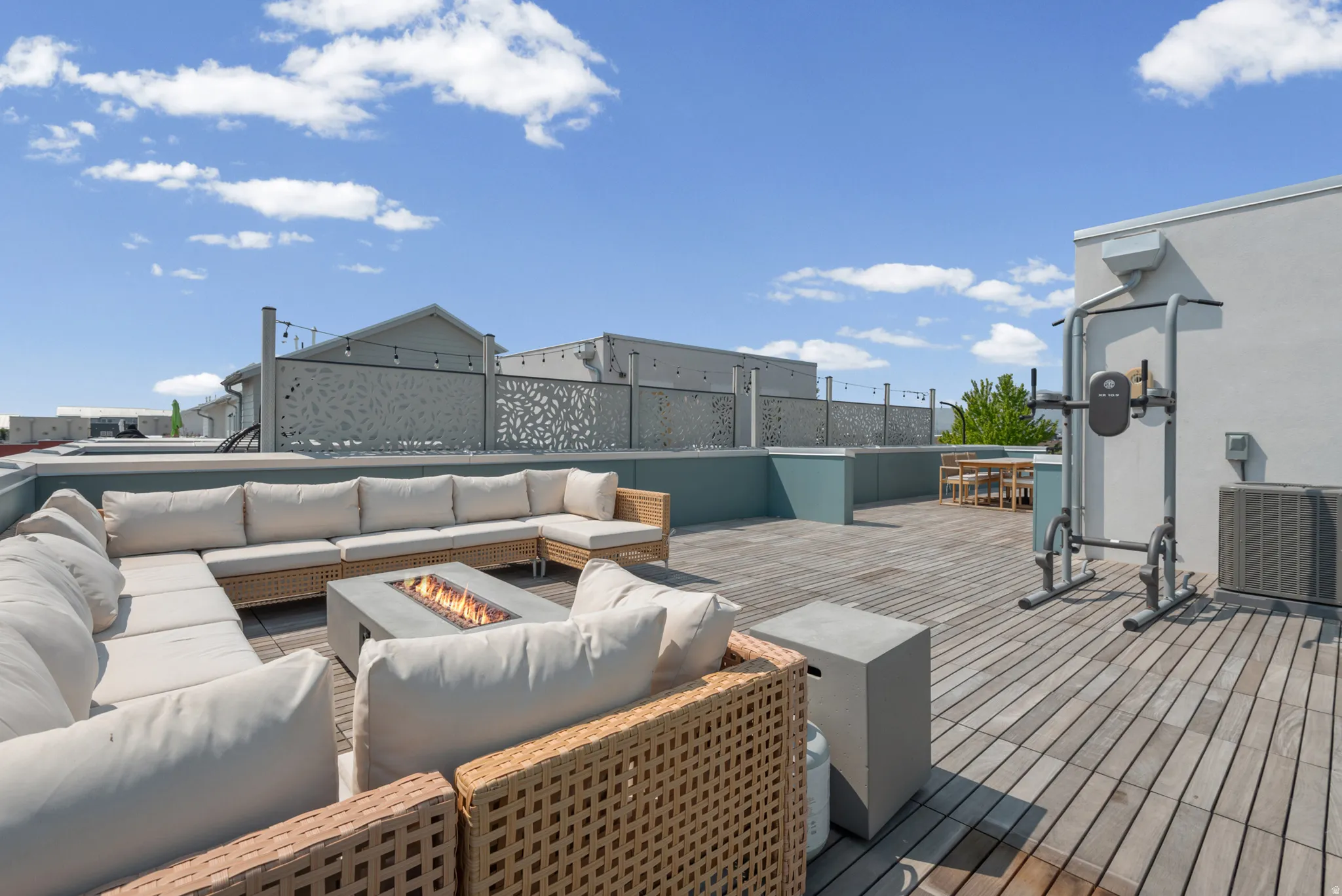 Rooftop deck featuring wood plank flooring, a built-in fire pit, and decorative privacy screens