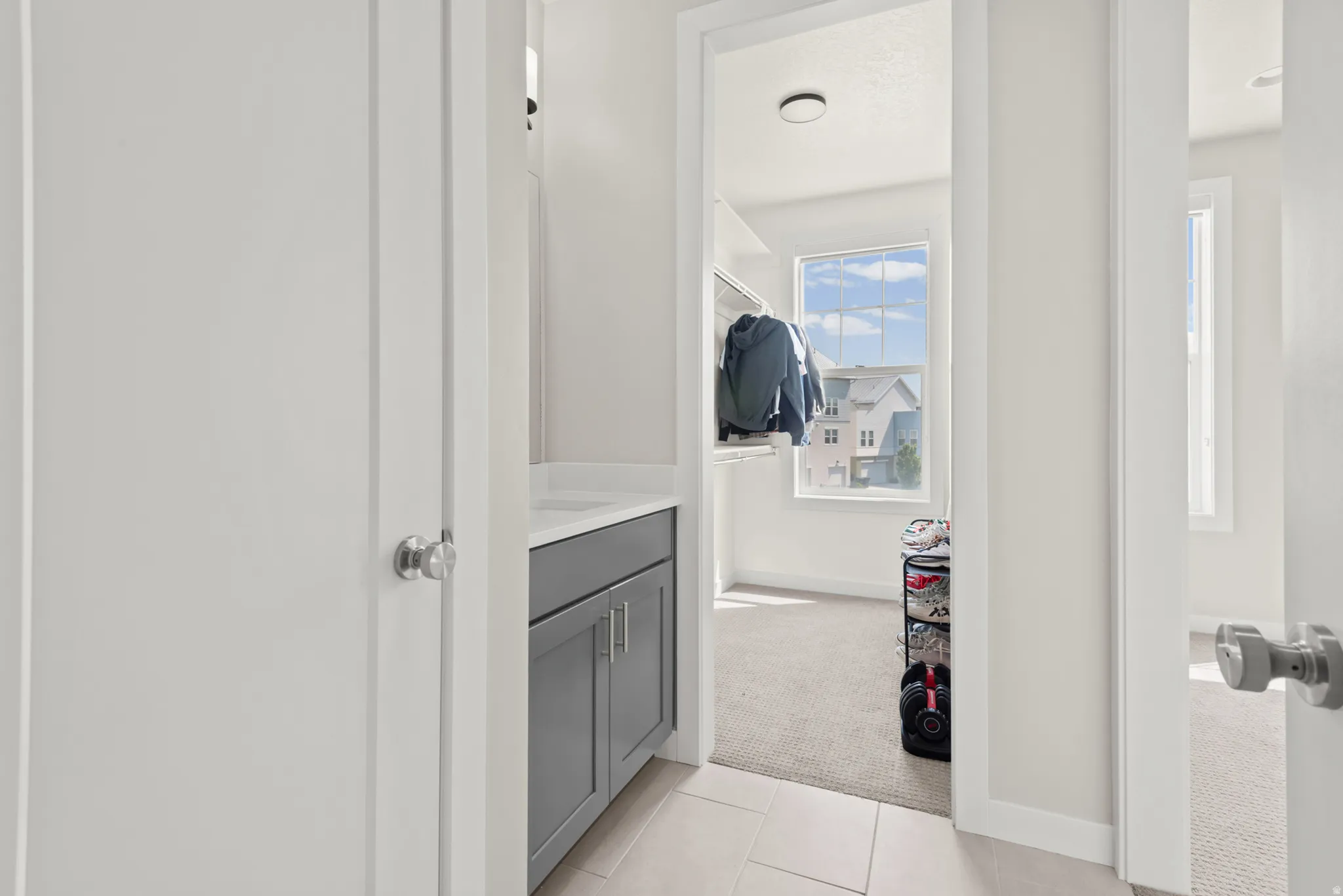 Hallway with a built-in vanity featuring a gray cabinet and white countertop
