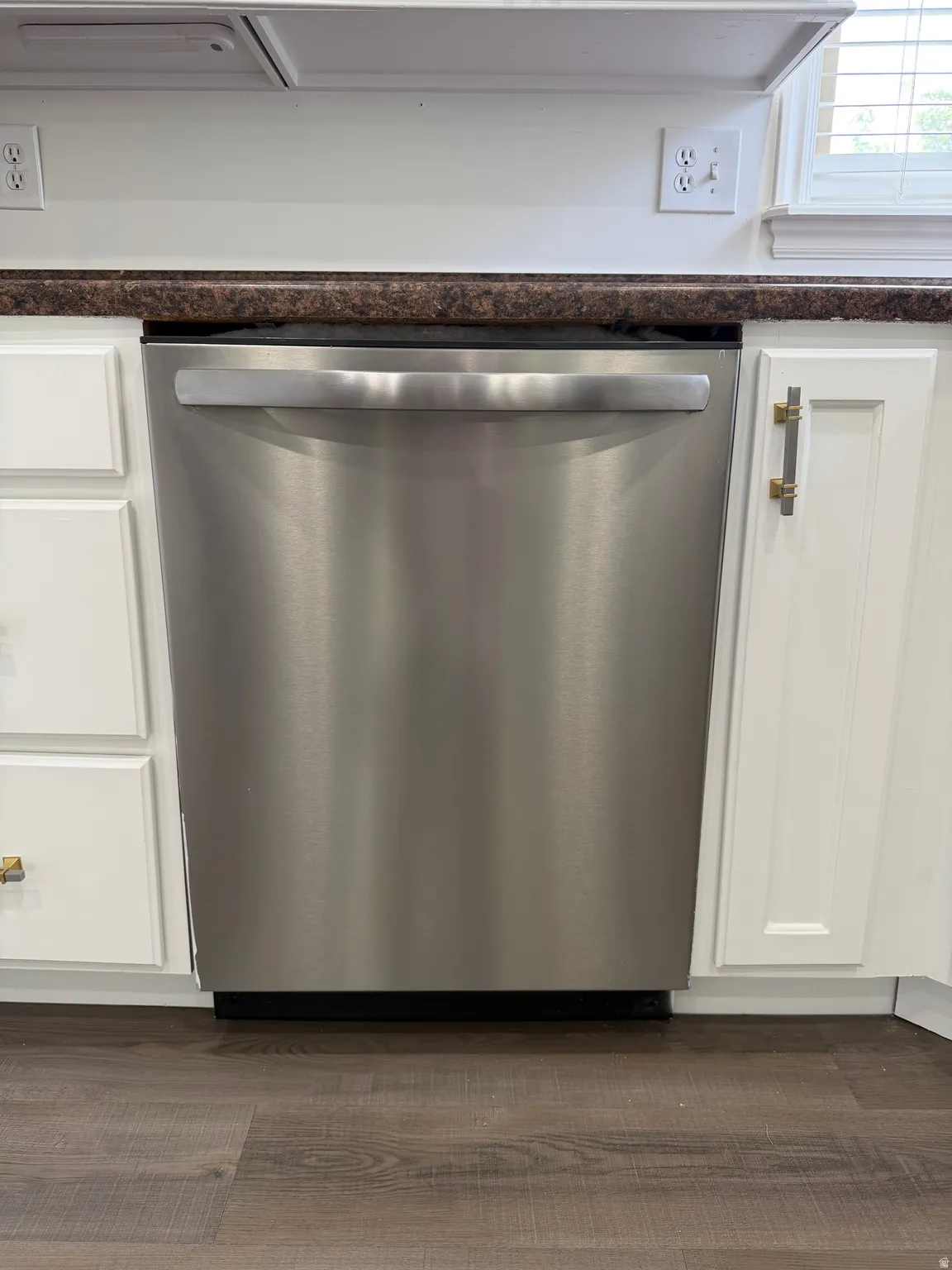 Kitchen view of dishwasher and white cabinetry