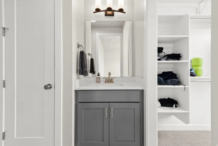 Vanity area featuring a rectangular undermount sink, quartz-finish countertop, and bronze-finish faucet