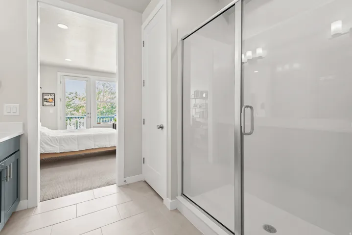 Glass-enclosed shower with contemporary light fixtures
