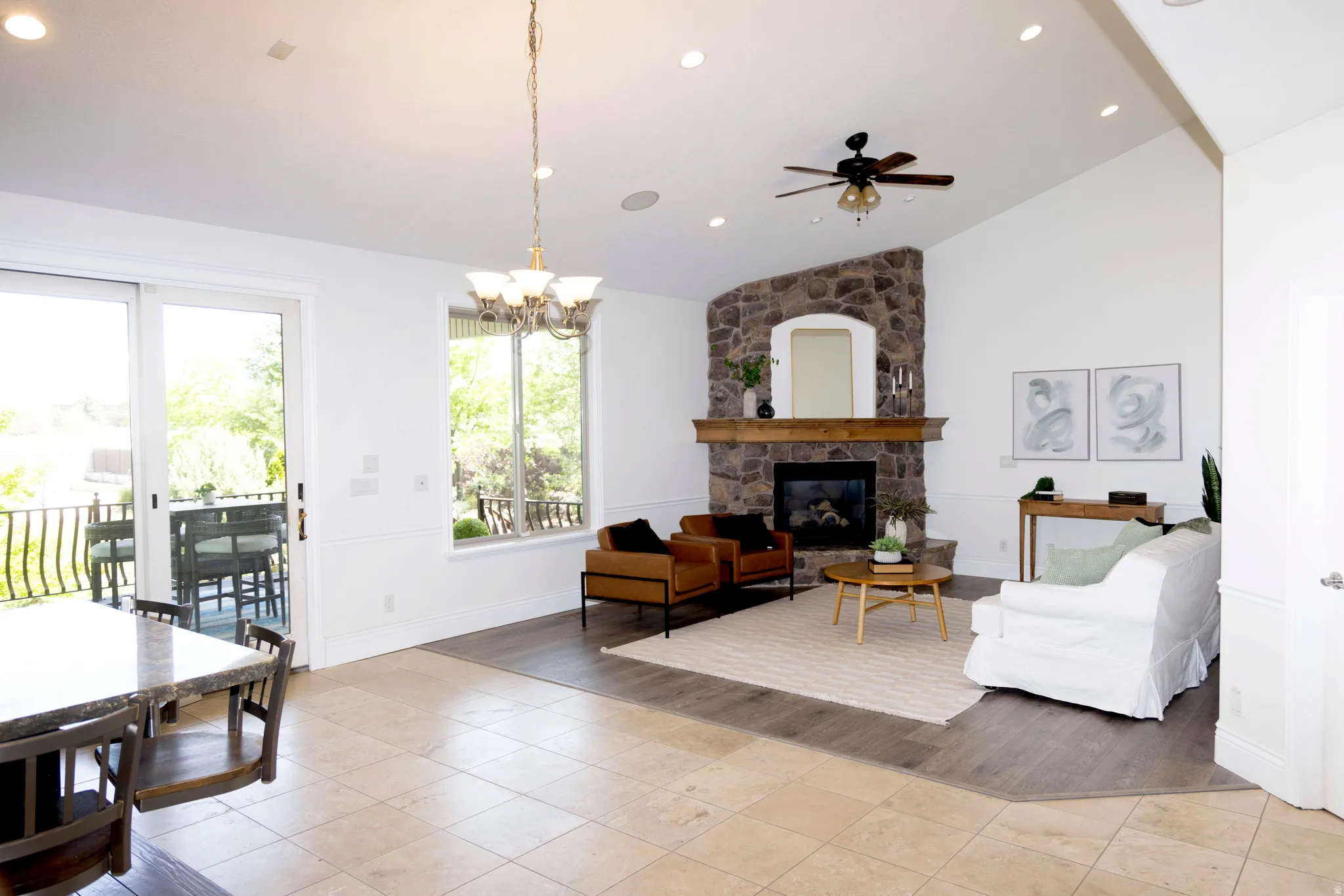 Vaulted living space with a stone-clad fireplace and wood mantle
