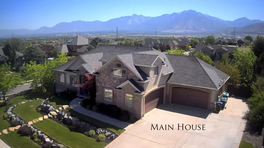 Expansive property featuring a stone and stucco exterior, multiple gables, and a dark shingle roof