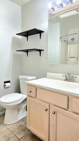 Full bath featuring vanity, light tile patterned floors, and a shower