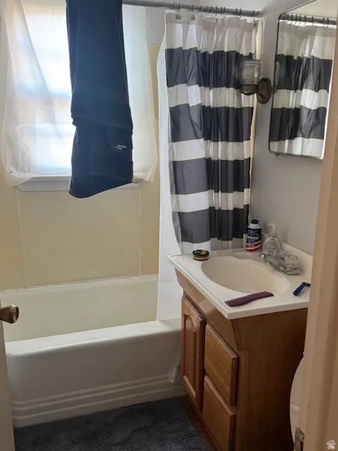 Bathroom featuring vanity and shower / bath combination with curtain