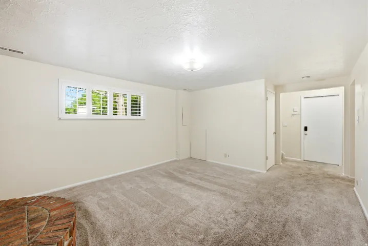 Unfurnished room with light carpet and a textured ceiling