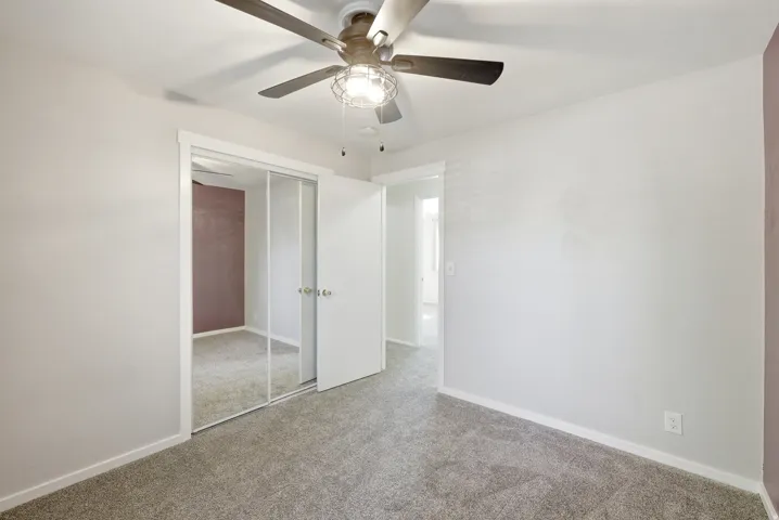 Unfurnished bedroom featuring carpet floors, a ceiling fan, and a closet
