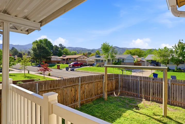 Fenced backyard with a mountain view, a residential view, and a porch