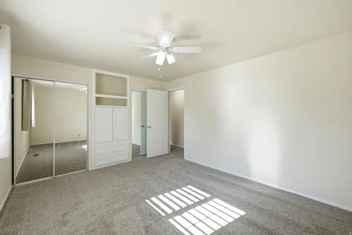 Unfurnished bedroom featuring carpet, a closet, and a ceiling fan