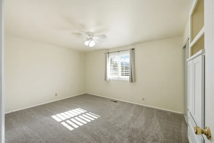 Unfurnished bedroom featuring a closet, carpet, and a ceiling fan