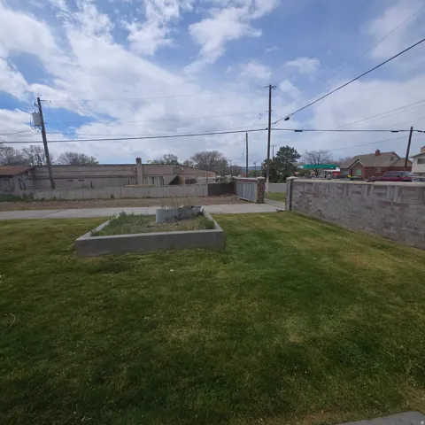 Fenced yard with a vegetable garden and an outbuilding