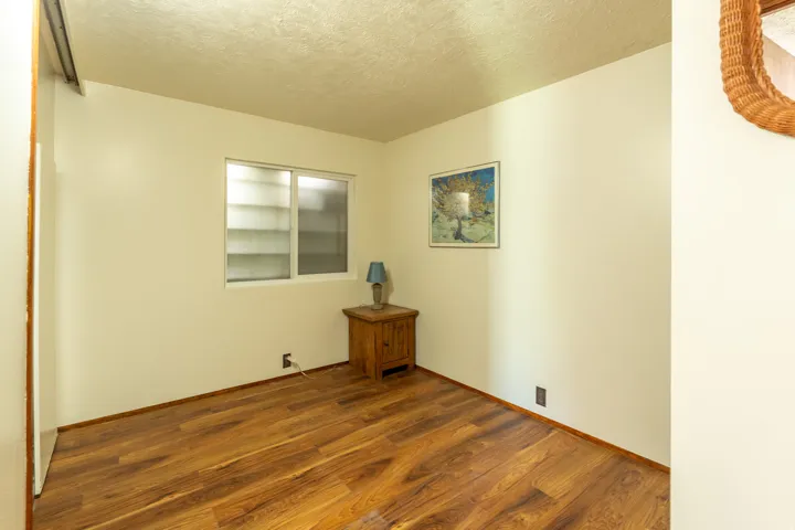 Empty room featuring a textured ceiling and wood finished floors