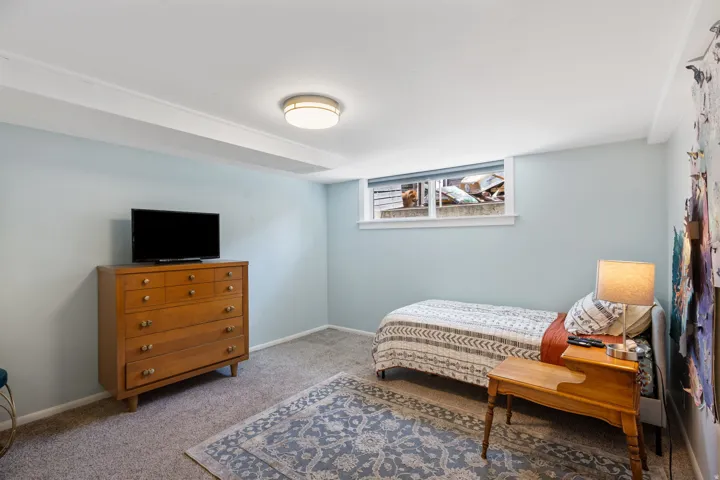 Bedroom featuring light carpet and baseboards