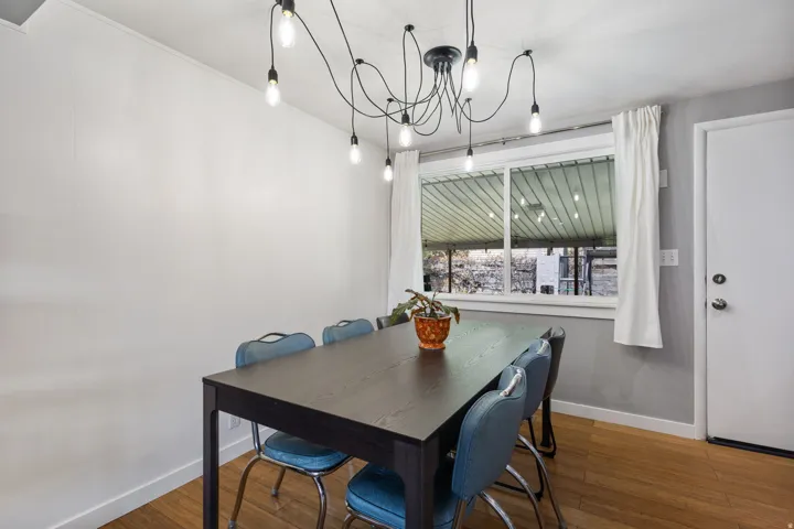 Dining room with wood finished floors and suspended lighting