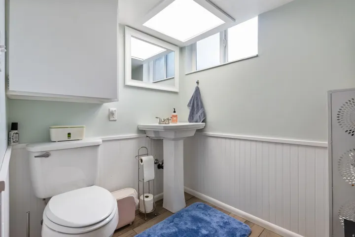 Bathroom with a wainscoted wall and light wood-style flooring