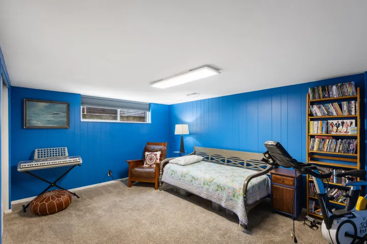 Carpeted bedroom with wood walls and baseboards