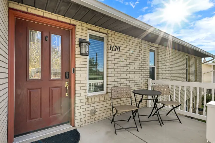 Brick exterior with an ornate wood entry door featuring decorative glass inserts