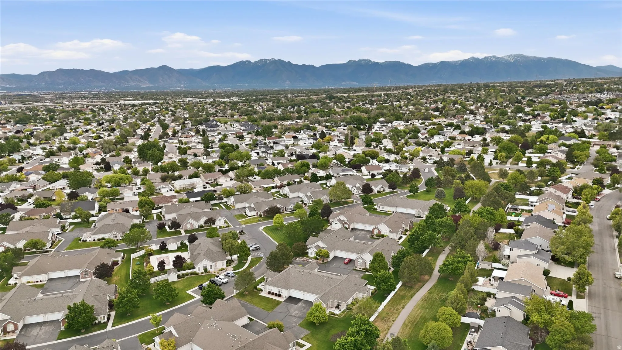 Expansive residential area featuring numerous single-family homes with pitched roofs, mature landscaping, and an extensive network of streets