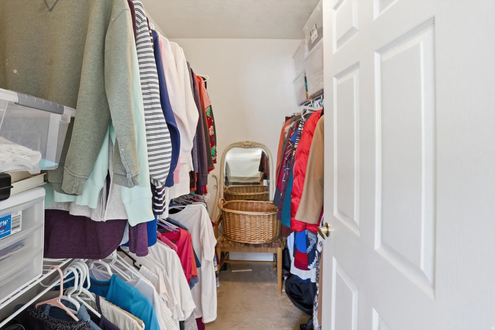 Walk-in closet with carpet flooring, white wire shelving, and a paneled white door