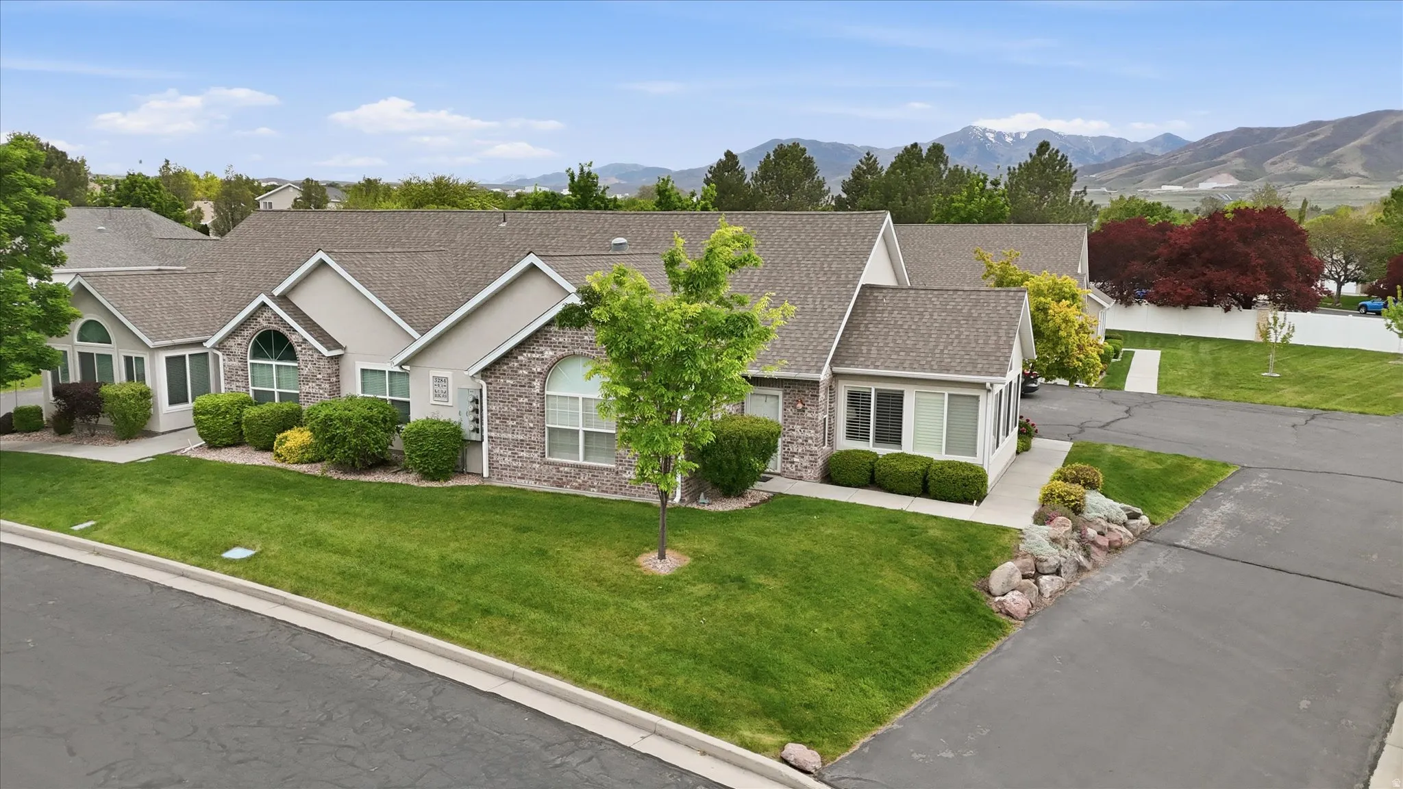 Single-story residence featuring a combination of stone veneer and siding, arched windows, and a shingled roof