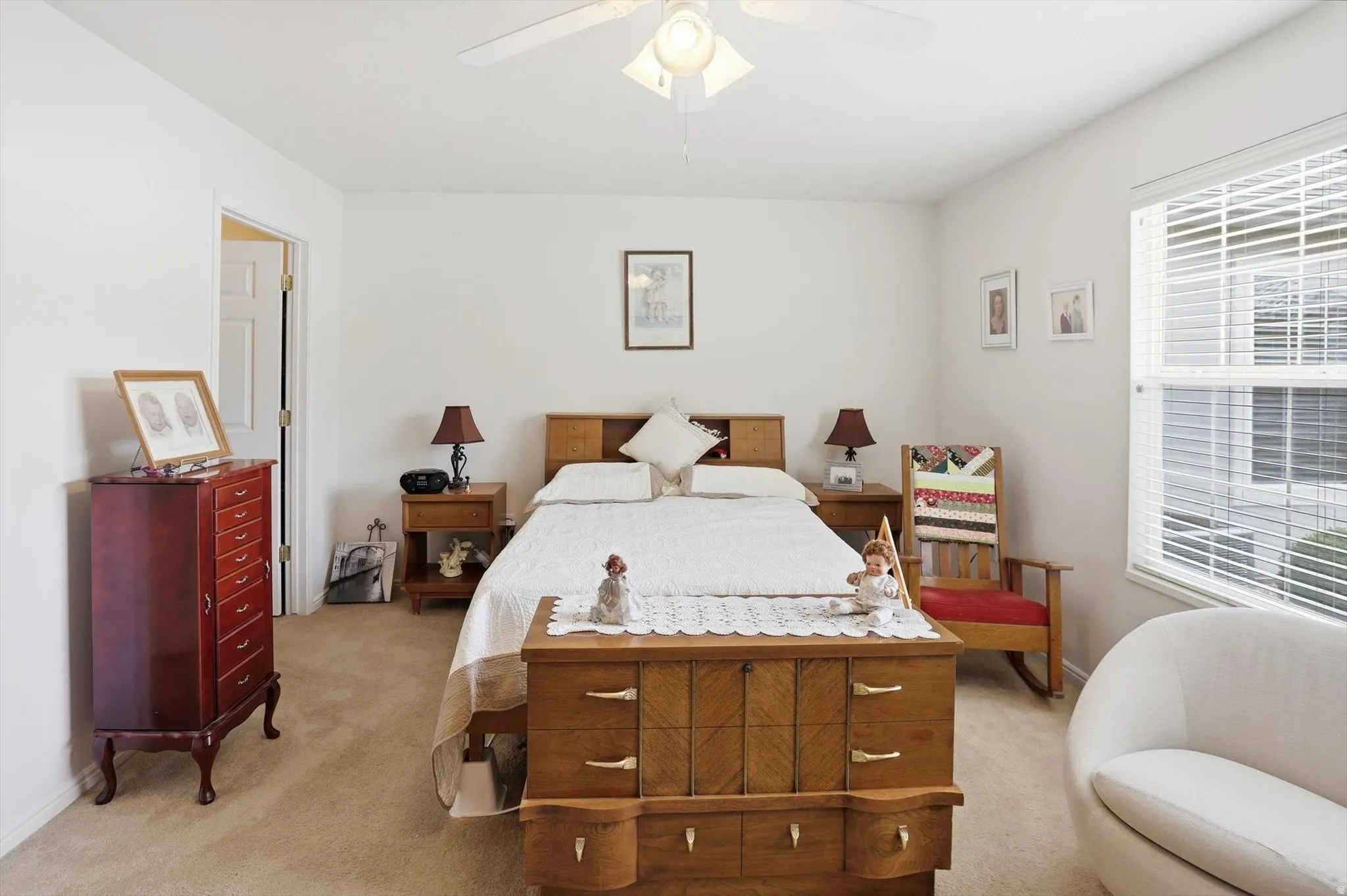 Carpeted room with a ceiling fan, a window with horizontal blinds, and a built-in wall niche