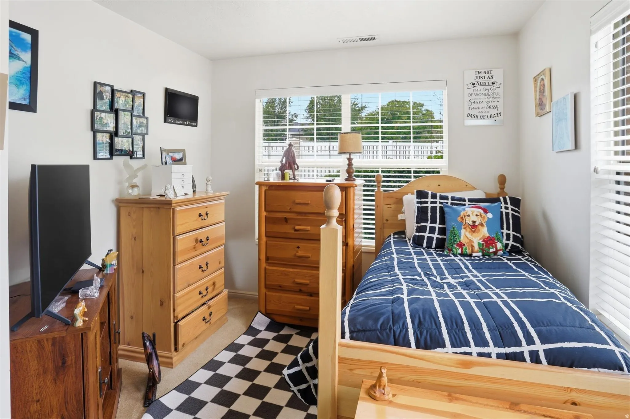 Bedroom featuring a single window with horizontal blinds, neutral wall paint, and beige carpeting